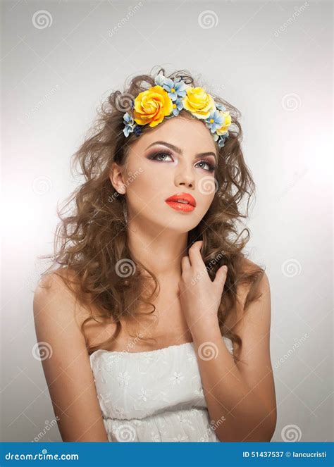 Portrait of Beautiful Girl in Studio with Yellow Roses in Her Hair and