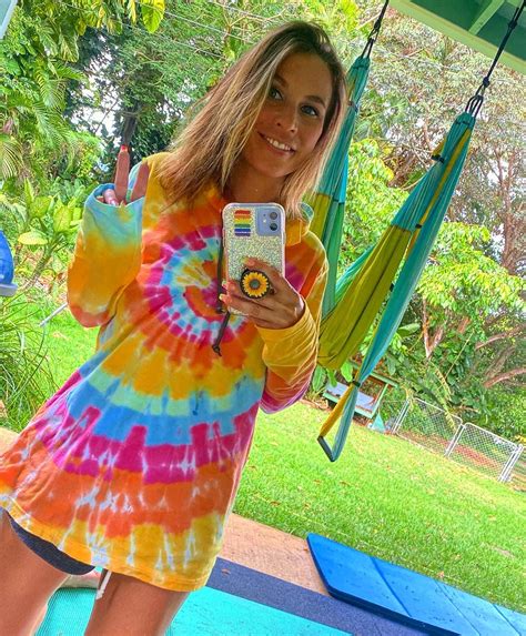 Lyssa Chapman Shows Her Toned Abs in a Deep Plunging Top and White Trousers