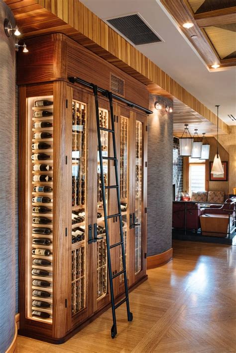 a wine cellar with ladders and bottles in it's display case on the floor