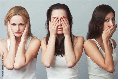 Close-up portrait of three young women in white sleeveless shirts ...