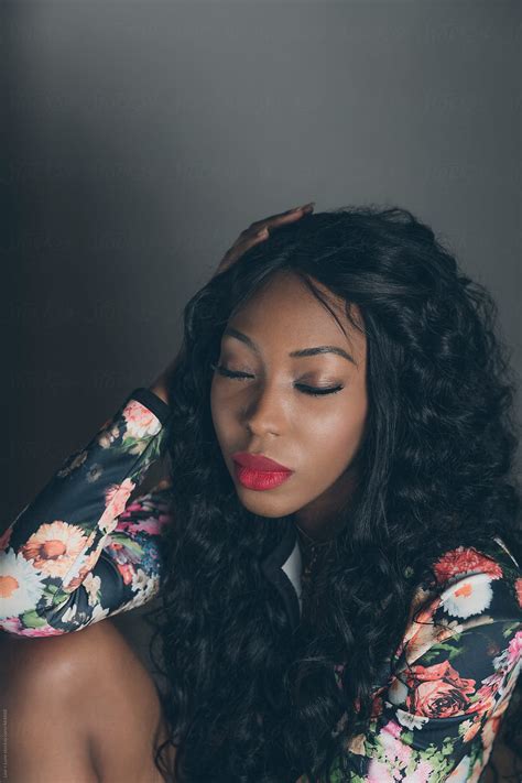 «Black Woman Sitting With Eyes Shut Against Grey Background» del