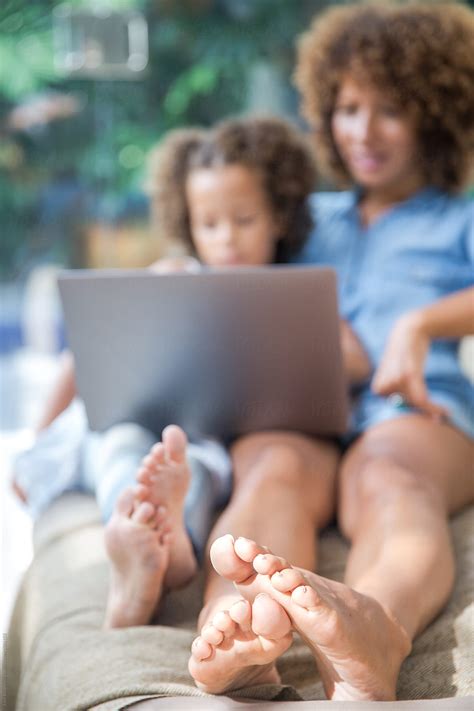 Mother And Daughter's Feet Relaxing On Sofa by Jovo Jovanovic