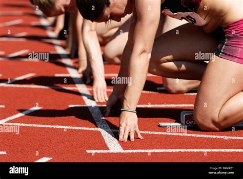 female runners anticipating start at starting line of track and field ...