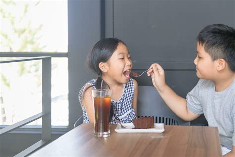 Asian brother feeds the cakes to his sister 25237713 Stock Photo at