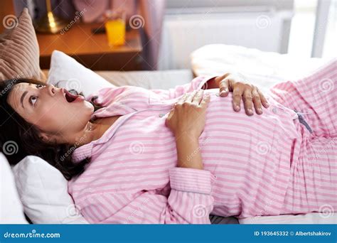 Shocked Pregnant Woman Screaming in Pain while Lying on the Bed Stock ...