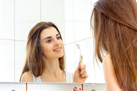 young beautiful woman brushing teeth before bed and smiles 16096933