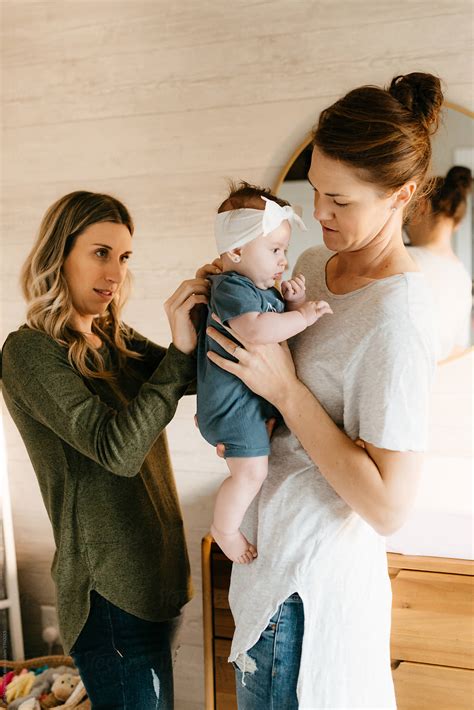 "Two Lesbian Moms In Babies Nursery Together." by Stocksy Contributor