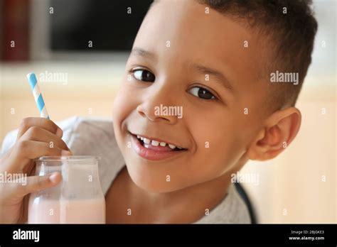 cute african american boy drinking yogurt  home closeup stock photo