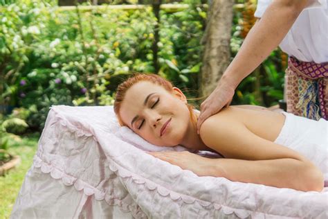 Young beautiful woman relaxing in spa massage outside in tropical