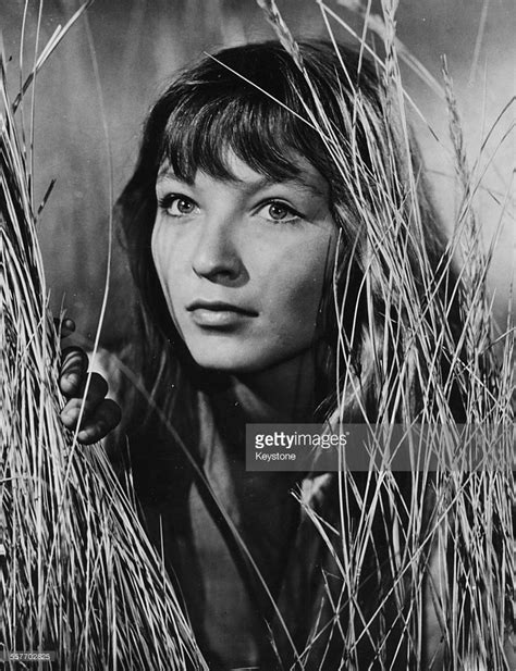 an old black and white photo of a woman in tall grass