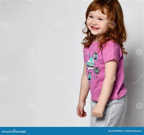 Shy Smiling Cutie Smiling Little Toddler Girl in Sportswear Studio Shot