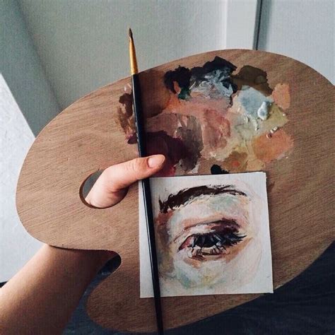 a person holding a paintbrush over a piece of paper with an image of a ...