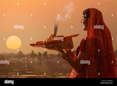 woman from Bihar offers prayers to the sun in the early morning hours ...