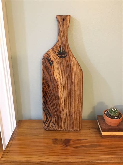 Zebrawood charcuterie board with blue epoxy filling voids and finished