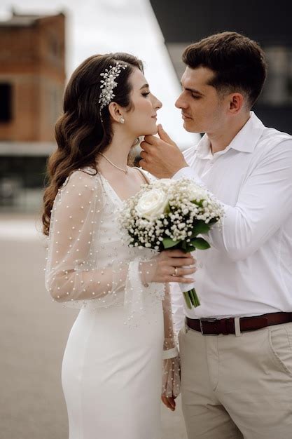 Premium Photo | A bride and groom pose for a photo in front of a building