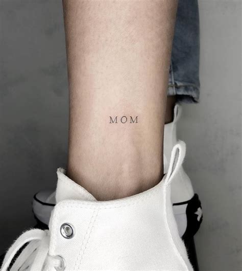 Tattoo of the word "MOM" located on the ankle.