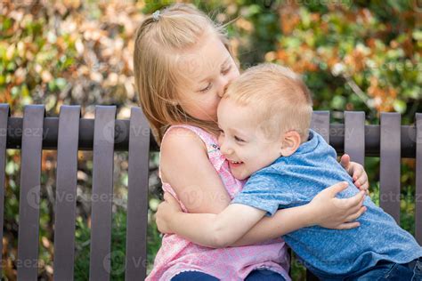 Young Sister and Brother Having Fun On The Bench At The Park 16357748