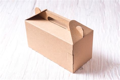 Premium Photo | Cardboard box with handle on wooden table