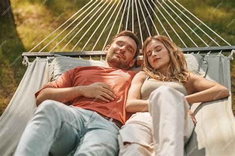 Premium Photo | Young couple napping on hammock in nature