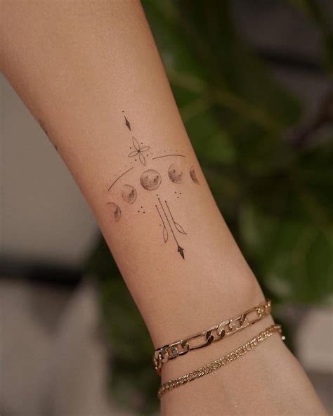 Fine line ornamental moon phases tattoo located on the