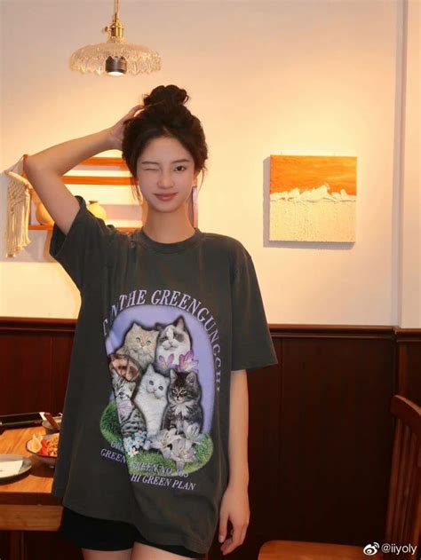 woman standing  front   table wearing   shirt  cats