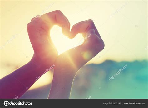 female hands showing heart sign sunlight stock photo  avgustin