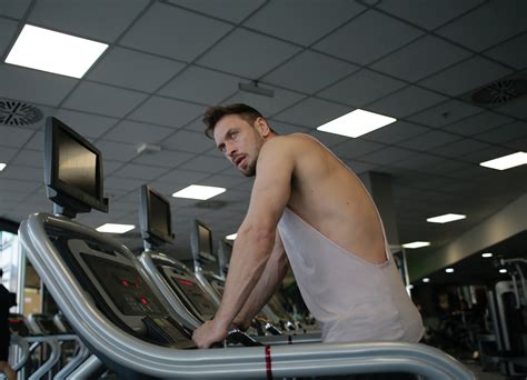 Man in White Tank Top Standing on TreadmillFree Stock Photo