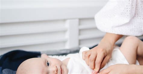 Baby in White Onesie Lying on Bed · Free Stock Photo