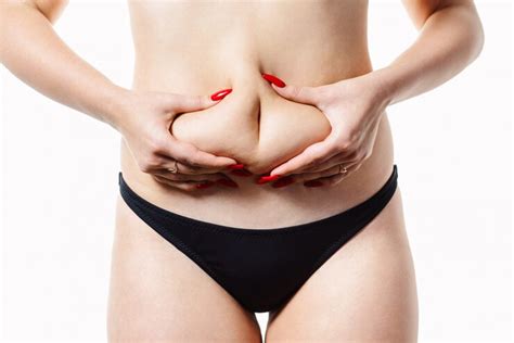 Premium Photo | Woman holds a fold of fat on her waist. conceptual