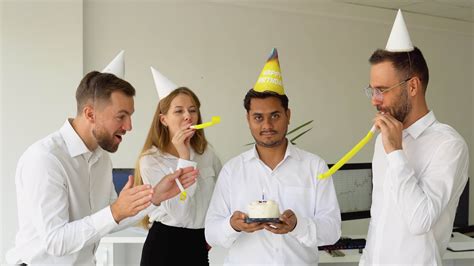 Indian office worker is blow candles on cake and make a wish while