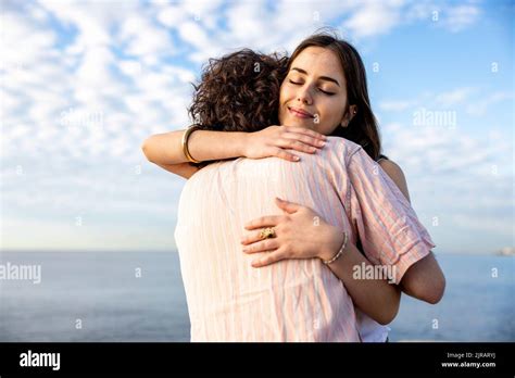 Smiling young girlfriend embracing boyfriend Stock Photo - Alamy
