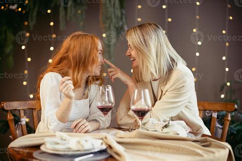 lesbian couple having dinner in a restaurant. Girls drink wine and talk