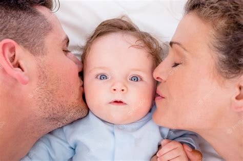 Premium Photo | Loving parents kissing baby