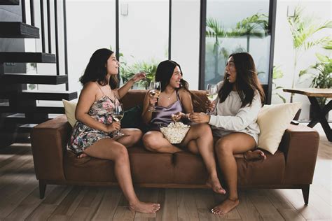 A Group of Friends Sitting on the Couch Talking while Holding Drinks ...