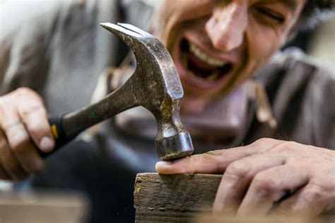carpenter accidentally hit  finger  hammer stock photo
