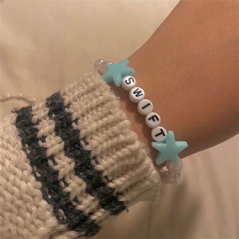 a close up of a person's arm wearing a bracelet with letters on it