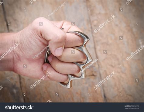 knuckle weaponshuman hand wearing brass knuckles stock photo edit