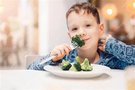 Menino Comendo A Madrasta - Menino comendo comida saudável de brócolis | Foto Premium