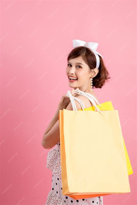 Compras mujer sosteniendo bolsas de compras en rosa | Foto Gratis