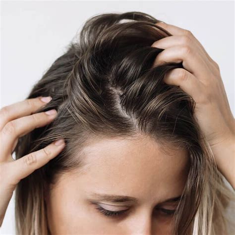 An image of a woman grasping her hair looking downward