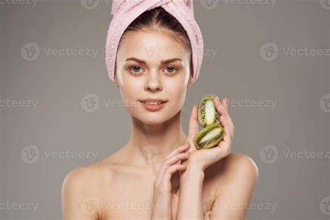 beautiful woman naked shoulders kiwi in the hands of spa treatments