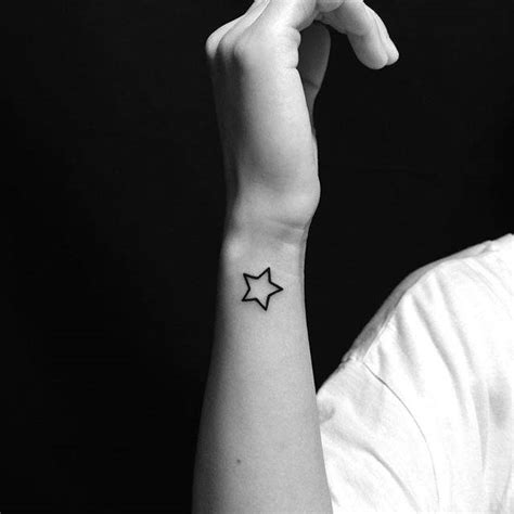 Star outline tattoo on the wrist.