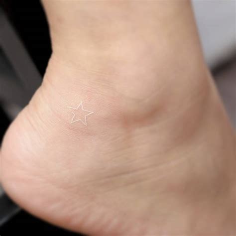 Small white star tattoo - Tattoogrid.net