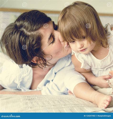 Happy Mother Kissing Daughter in the Bed Stock Photo - Image of kissing