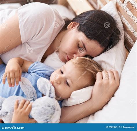 Mother and Son Sleeping on Bed Hugging Doll at Bedroom Stock Image