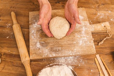 Close-Up Photo of a Person's Hands Holding a Piece of Dough · Free