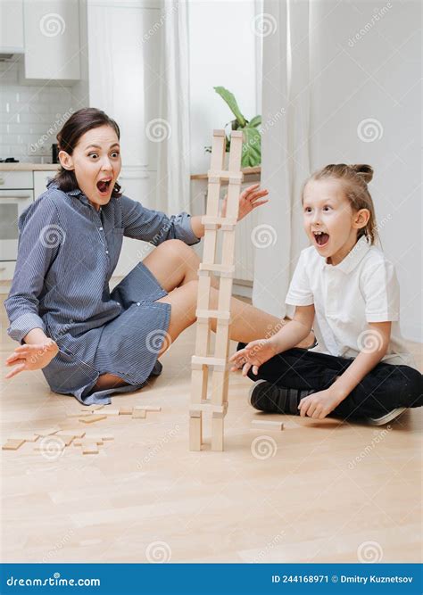 Surprised Mom and Son Watching Jenga Tower Fall To Side. Stock Image