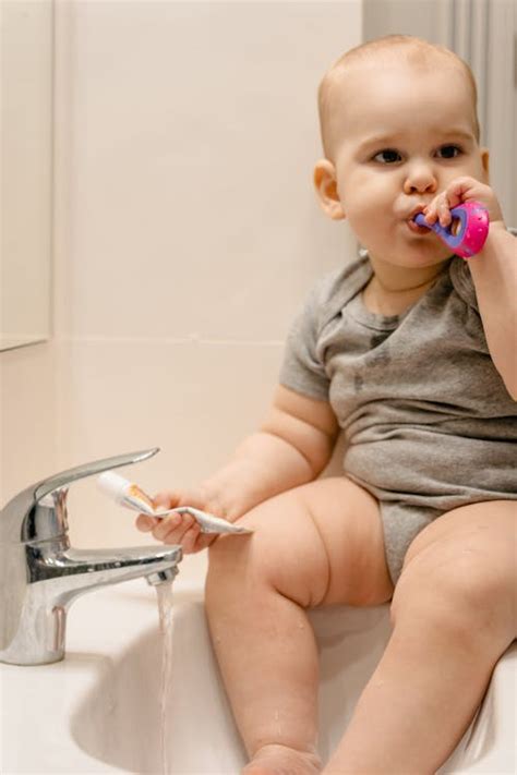 Photograph of a Baby Brushing His Teeth · Free Stock Photo