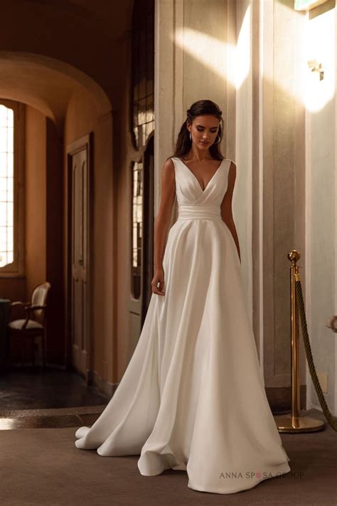 a woman in a white wedding dress standing on the floor