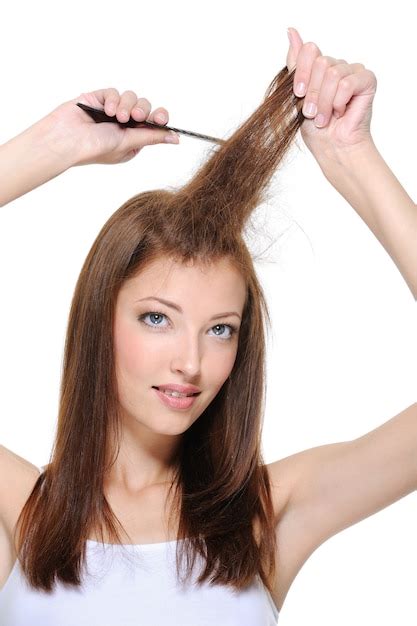빗으로 Backcombing을 하 고 젊은 갈색 머리 여자의 초상화 | 무료 사진